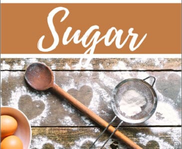 homemade powdered sugar, a wooden spoon, a sifter, and eggs on a table
