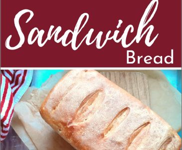 sourdough discard sandwich loaf on a cutting board with a red and white striped towel and knife